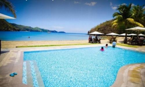 a swimming pool with a view of the ocean at Pico hamilo coast condotel suite in Nasugbu
