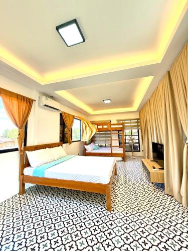 a bedroom with a large bed and a television at Villa de Flynn Private Resort in Bauang