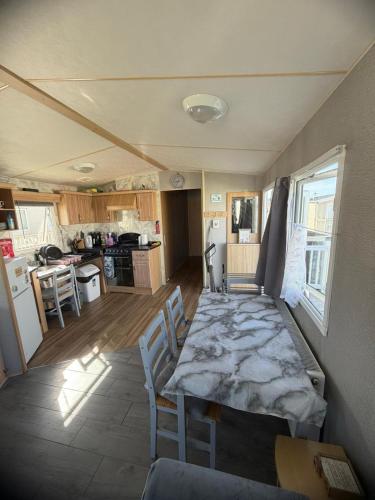 a room with a table and chairs in a kitchen at Accessible and dog friendly caravan in Ingoldmells