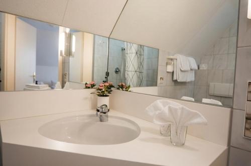 a bathroom with a sink and a mirror at Hotel & Restaurant Krone in Märkt in Weil am Rhein