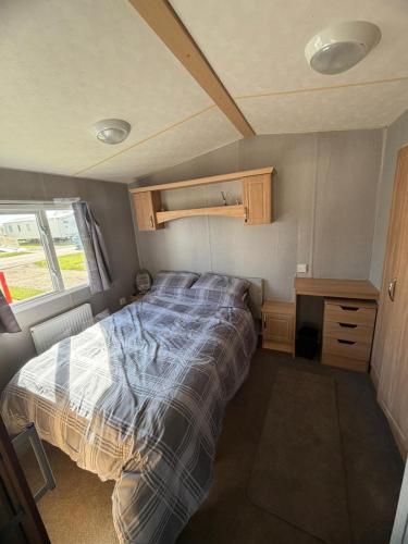 a bed in a small room in a trailer at Accessible and dog friendly caravan in Ingoldmells