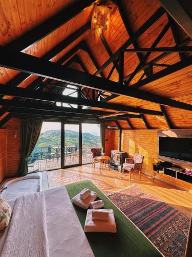 a living room with a bed and a large window at Defne Bungalow Yomra in Yomra