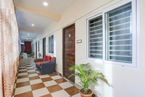 a hallway with a couch and a chair and a window at Hotel O Aqua Comforts in Yelahanka