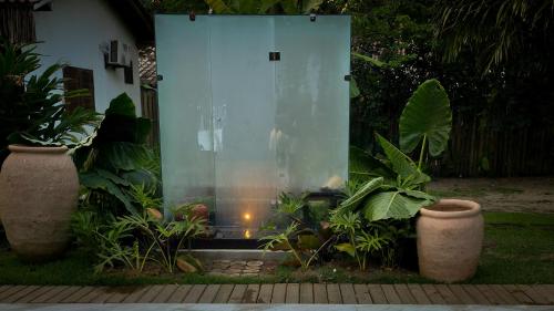 a glass wall in a garden with plants at Villa Cacau - Floresta in Trancoso