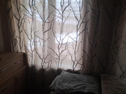 a bedroom with a window with a tree curtain at Hotel kazbegi1 in Ach'khoti
