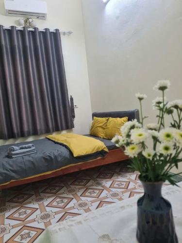 a bed in a room with a vase with flowers at Snow Homestay in Ninh Binh