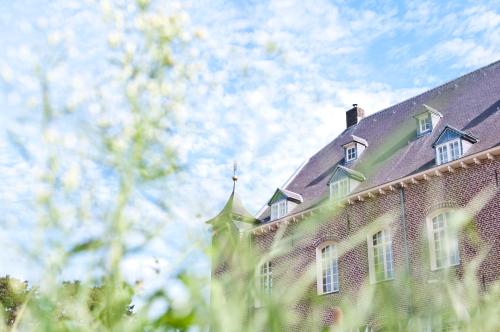 a large brick building with a roof at Kasteel Aldenghoor in Haelen