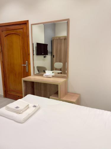 a room with a mirror and a bed and a desk at Alturya in Al-ʿUla