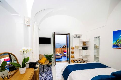 a bedroom with a bed and a desk and a mirror at Luxury Maison Cherie - Positano Charme & Sea View in Positano