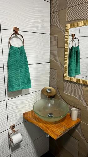 a bathroom with a green sink and a mirror at Chalé do Lago - Refúgio Arara Azul in Urubici