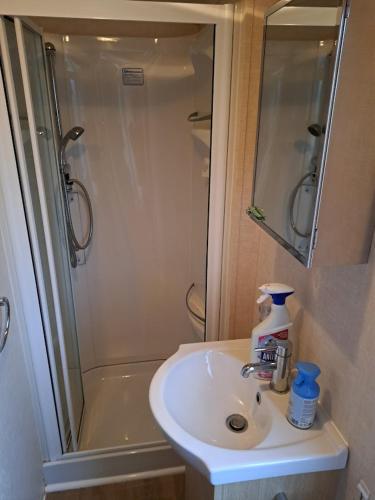 a bathroom with a sink and a shower at Cozy corner house, New vennepark in De Haan