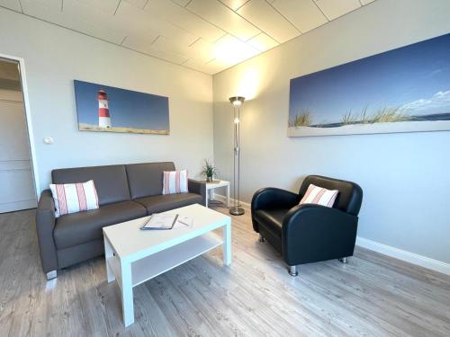 a living room with a couch and a table and a lighthouse at App 12-A67 in Westerland