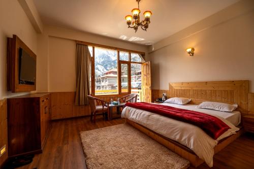 a bedroom with a large bed and a window at Jawai Himalayan Cottage in Vashisht