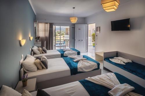 a hotel room with three beds and a television at Cloud9 Hotel Shisha & Cocktail Bar - Adults Only in Malia
