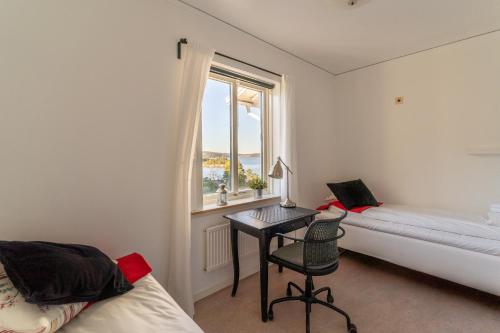 a bedroom with a desk and a window and a bed at Åh Stifts- & Konferensgård in Ljungskile