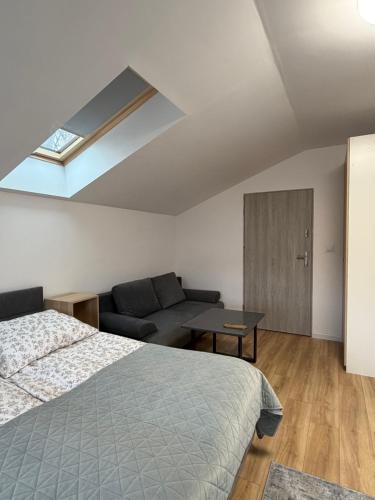 ein Schlafzimmer mit einem Bett und einer Couch in der Unterkunft Jesion in Inowrocław
