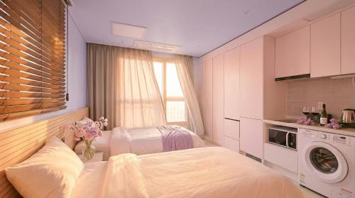 a bathroom with two beds and a washing machine at World Sky Residence Hotel in Sokcho
