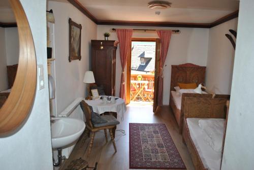 a bathroom with a sink and a bed and a table at Café Pension Leopoldine in Hallstatt