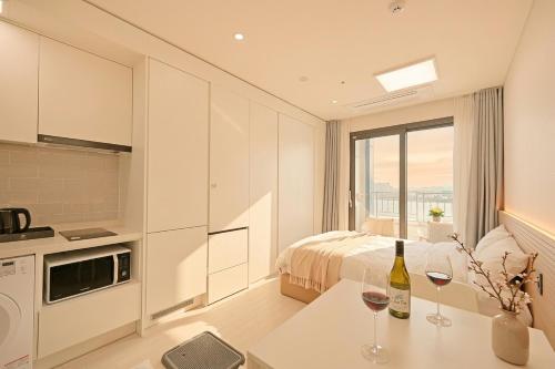 a bedroom with a bed and two wine glasses on a table at World Sky Residence Hotel in Sokcho