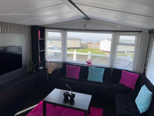 a living room with a black couch and a table at 107 Arran View with WiFi in Ayr