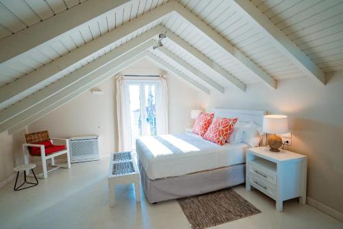 a white bedroom with a bed and a window at Irini's Bayside Loft in Fiskardo