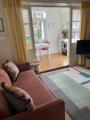 a living room with a couch and a kitchen at Spacious comfortable flat with free parking in East Finchley, Muswell Hill & close to Alexandra Palace in London