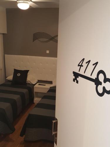 a bedroom with two beds and a wall with a clock at Dodo Suites in Mar del Plata