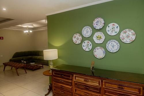 a living room with plates on a green wall at Pousada Vilage Inn Campos do Jordão in Campos do Jordão