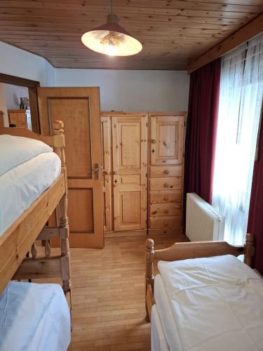a bedroom with two bunk beds and a window at Campiglio Trilocale Cima Tosa in Madonna di Campiglio