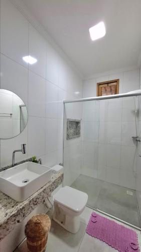 a white bathroom with a toilet and a sink at Casa do Brother in Prado