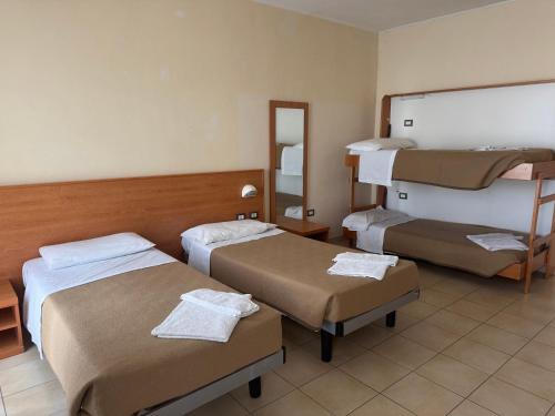 a hospital room with three beds and a mirror at Hotelleria di Ovada in Ovada