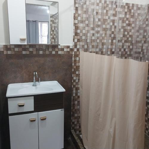 a bathroom with a sink and a shower curtain at Pousada Bom Bocado in São Pedro da Serra
