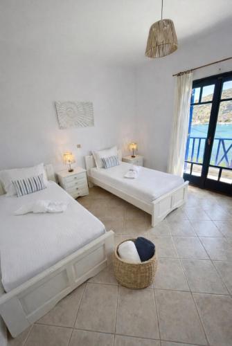 a white room with two beds and a couch at Thalassa house by the sea in Áyios Yeóryios