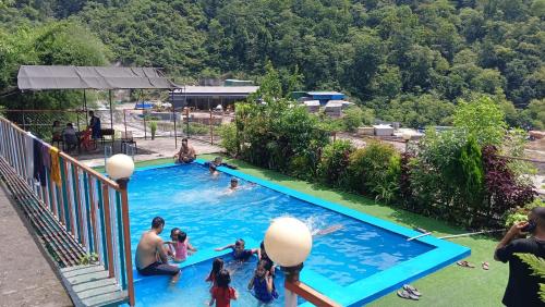 a group of people playing in a swimming pool at Shivpuri Hills Camp in Jāmb