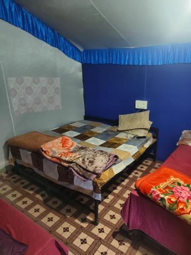a room with two beds and a blue wall at Shivpuri Hills Camp in Jāmb