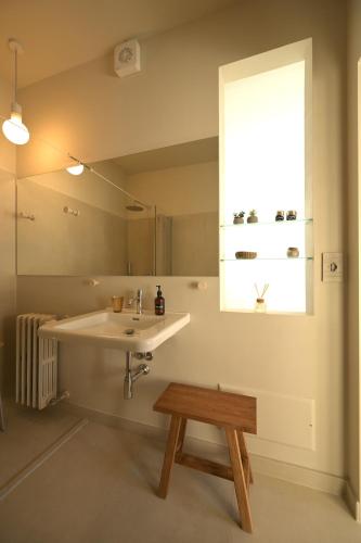 a bathroom with a sink and a window and a bench at B&B Il Faggio Rosso in Vernante