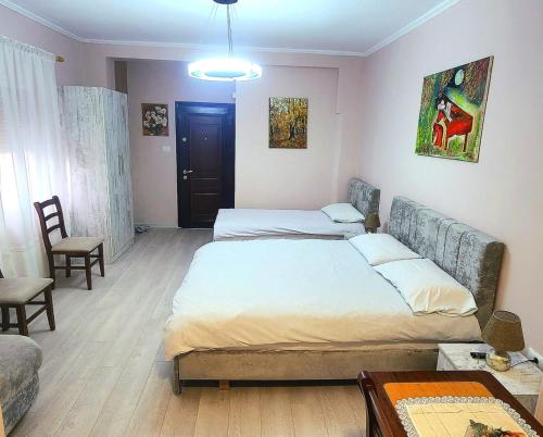 a bedroom with two beds and a couch and a table at ERLA'S apartment in Tirana