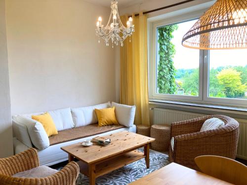a living room with a couch and a table at Ferienwohnung am Maximilianpark Hamm - Dachterrasse, Highspeed-WLAN, 2 Schlafzimmer in Hamm