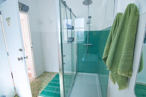 a bathroom with a shower with green tiles at Guest House D'Avenida in Vila Praia de Âncora