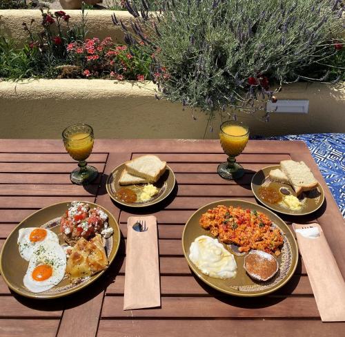 a wooden table with plates of breakfast food on it at Anatelo house in Fira