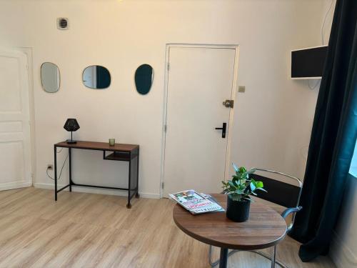 a room with a table and a door with mirrors at Le refuge in Bellême