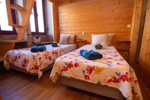 a bedroom with two beds in a log cabin at Guest House D'Avenida in Vila Praia de Âncora