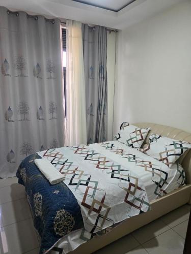 una camera da letto con un letto con lenzuola bianche e una finestra di Golden Flame a Kigali