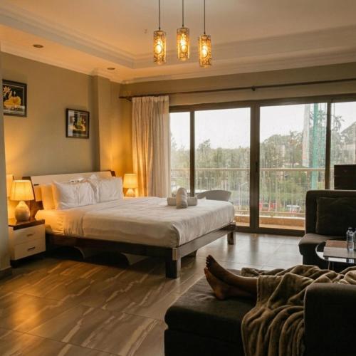 a bedroom with a bed and a large window at Eldon Hotel & Apartments in Nairobi