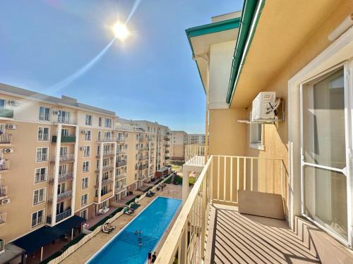 ein Balkon einer Wohnung mit Pool und Gebäuden in der Unterkunft SunSet Studio by Cosmopolis in Ştefăneştii de Sus
