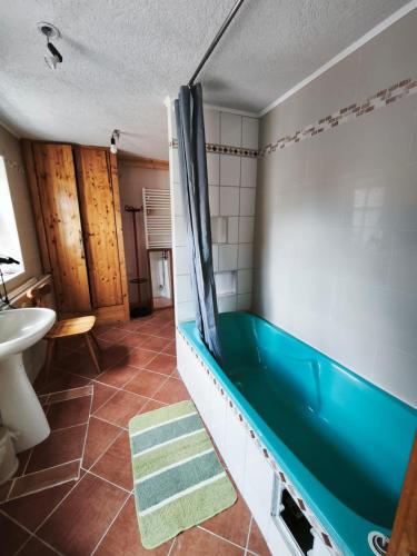 a bathroom with a tub and a sink at Ferienwohnung Leon in Heldburg