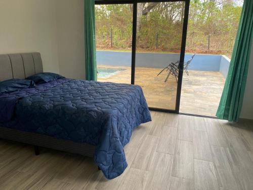 a bedroom with a bed and a large glass door at Coral Breeze in Puntarenas