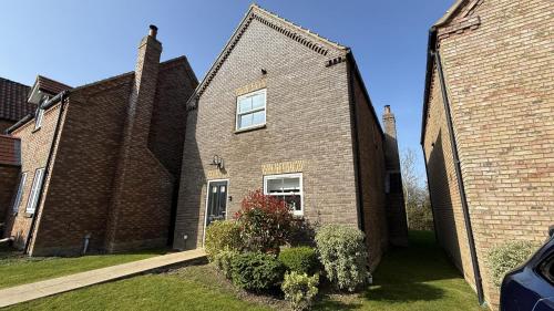 a brick house with a window on the side of it at Old England Cottage - Part of the The Bay Filey Holiday Village with pool, gym and direct beach access, pub, restaurant, tennis and meadows walks in Filey