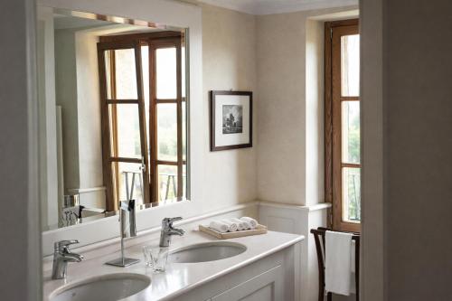 a bathroom with two sinks and a large mirror at Villa Arcadio in Salò