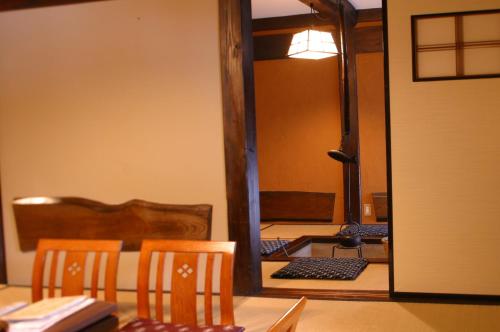 a room with a table and two chairs and a mirror at Yumoto Choza in Takayama